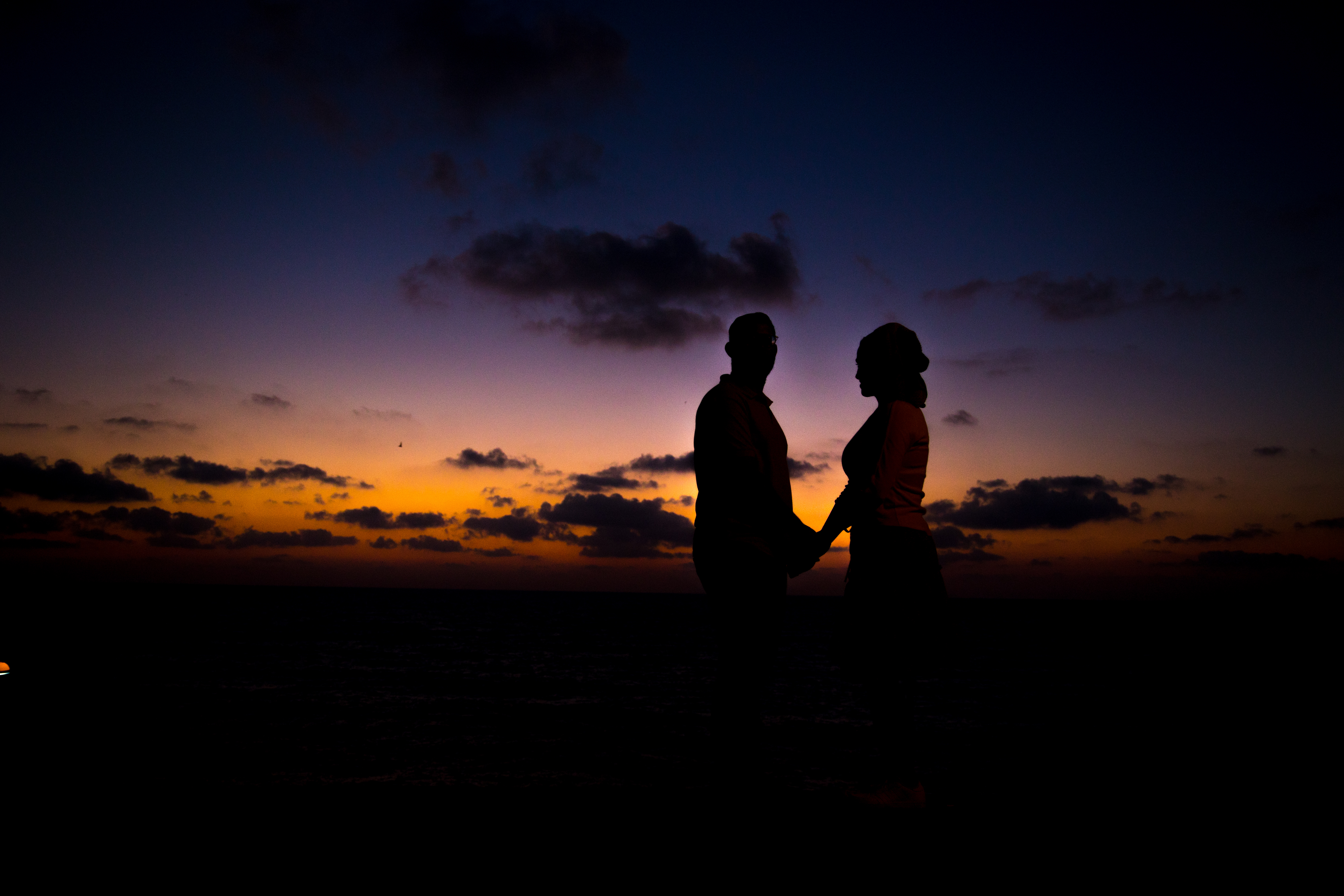 A couple silhouetted against the evening sky