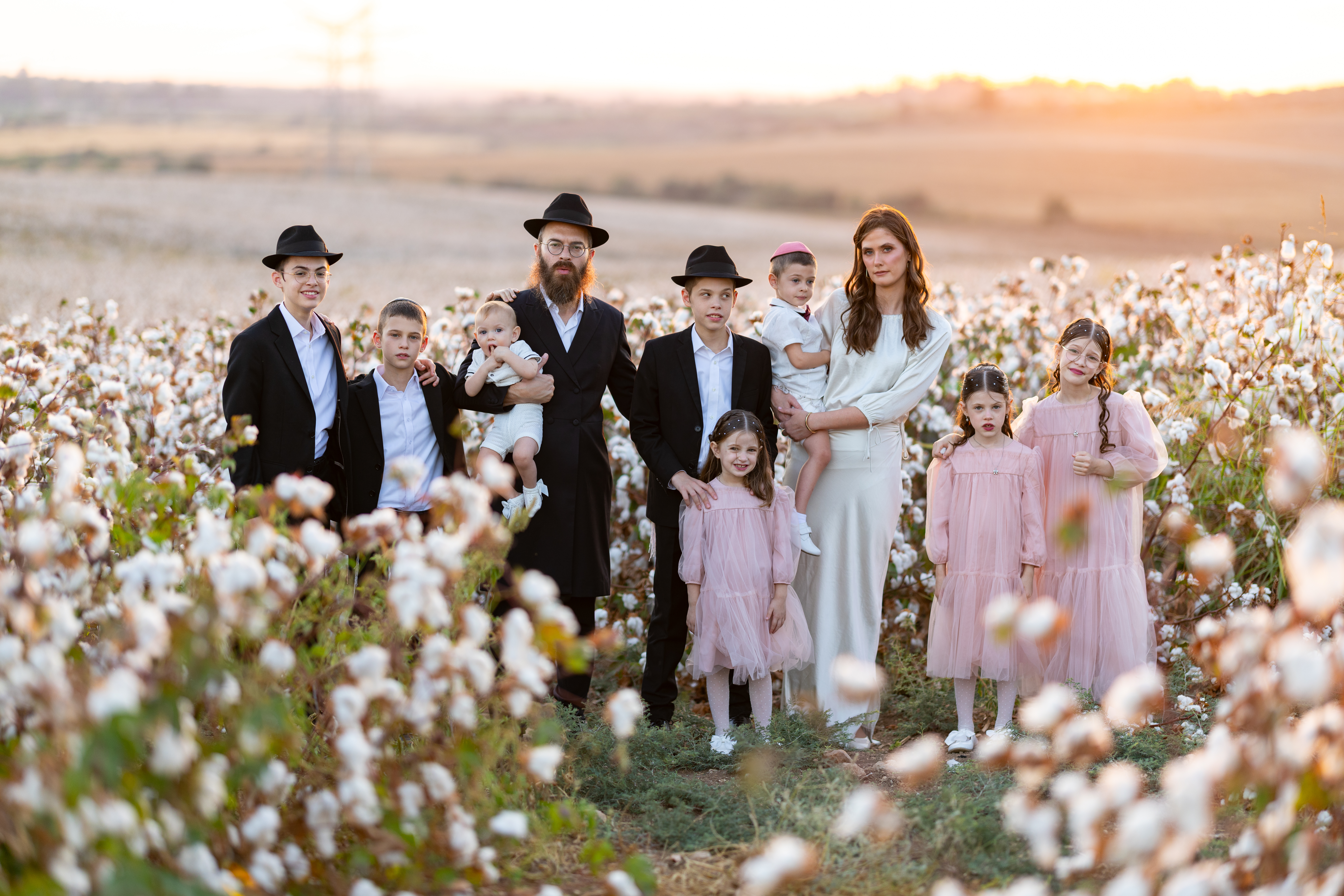 A family together in a field at sunset